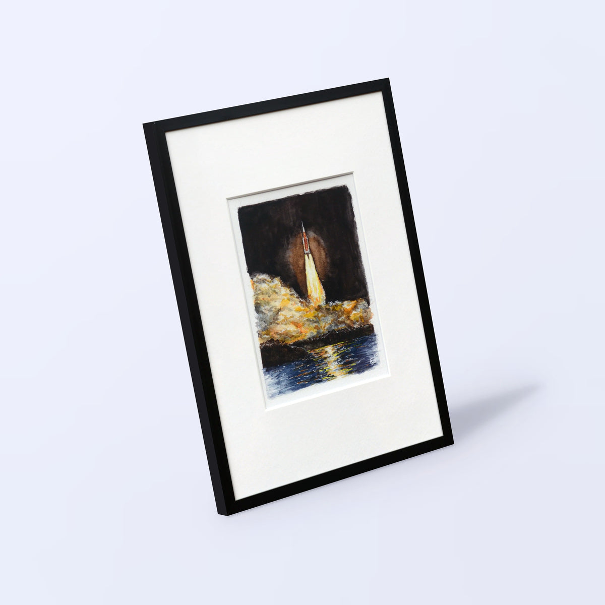 Artemis I watercolor print of the SLS launch in a black frame with white mat, angled view