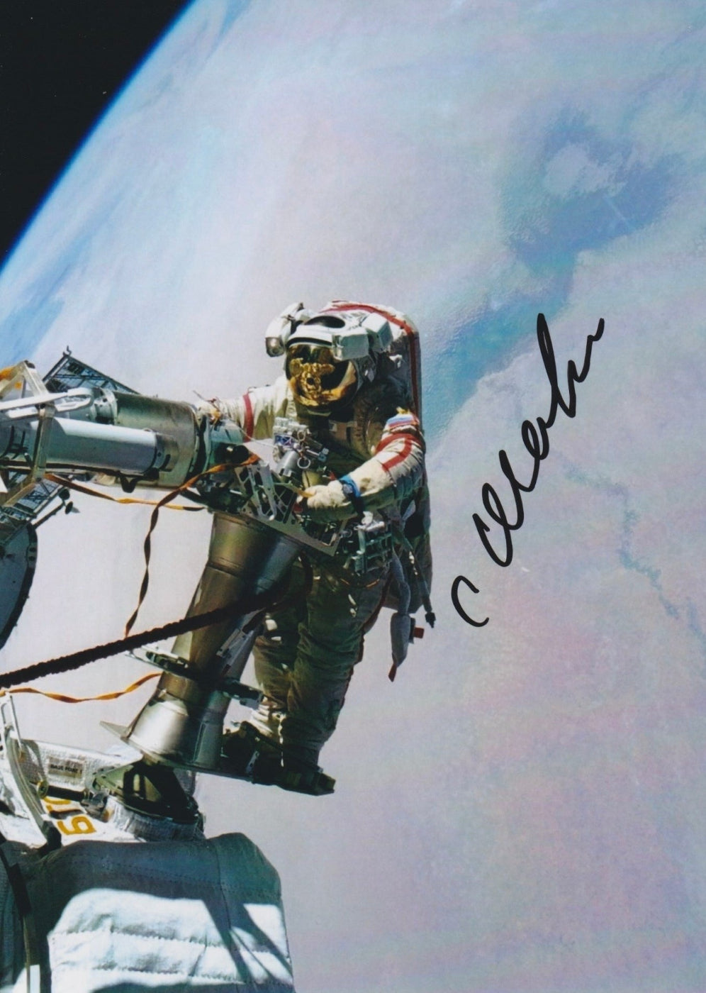 Autographed color photograph of cosmonaut Salizhan Sharipov conducting a spacewalk above Earth during his mission to the International Space Station.