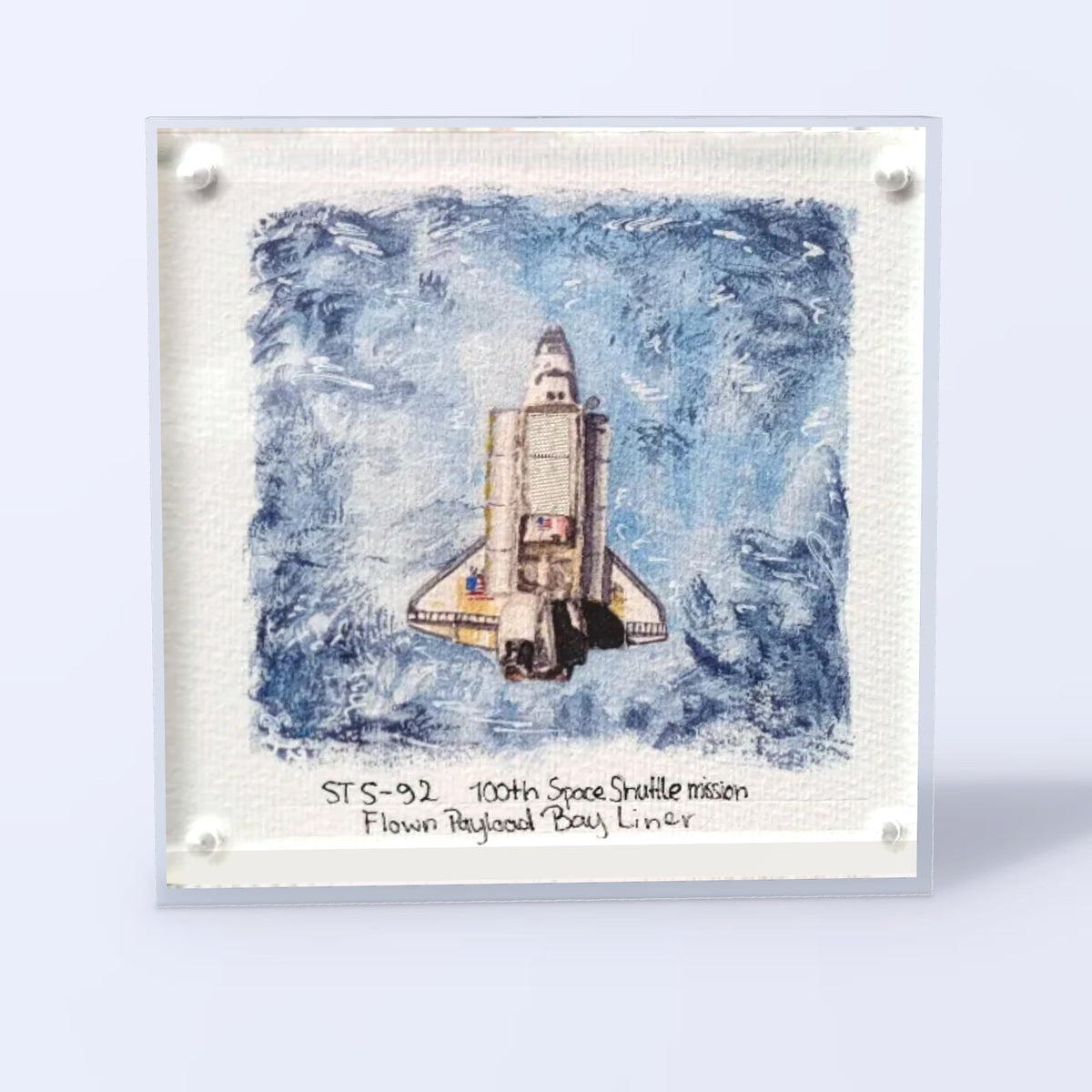 Acrylic display with a Space Shuttle fine art print and a flown STS-92 payload bay liner fragment, front view
