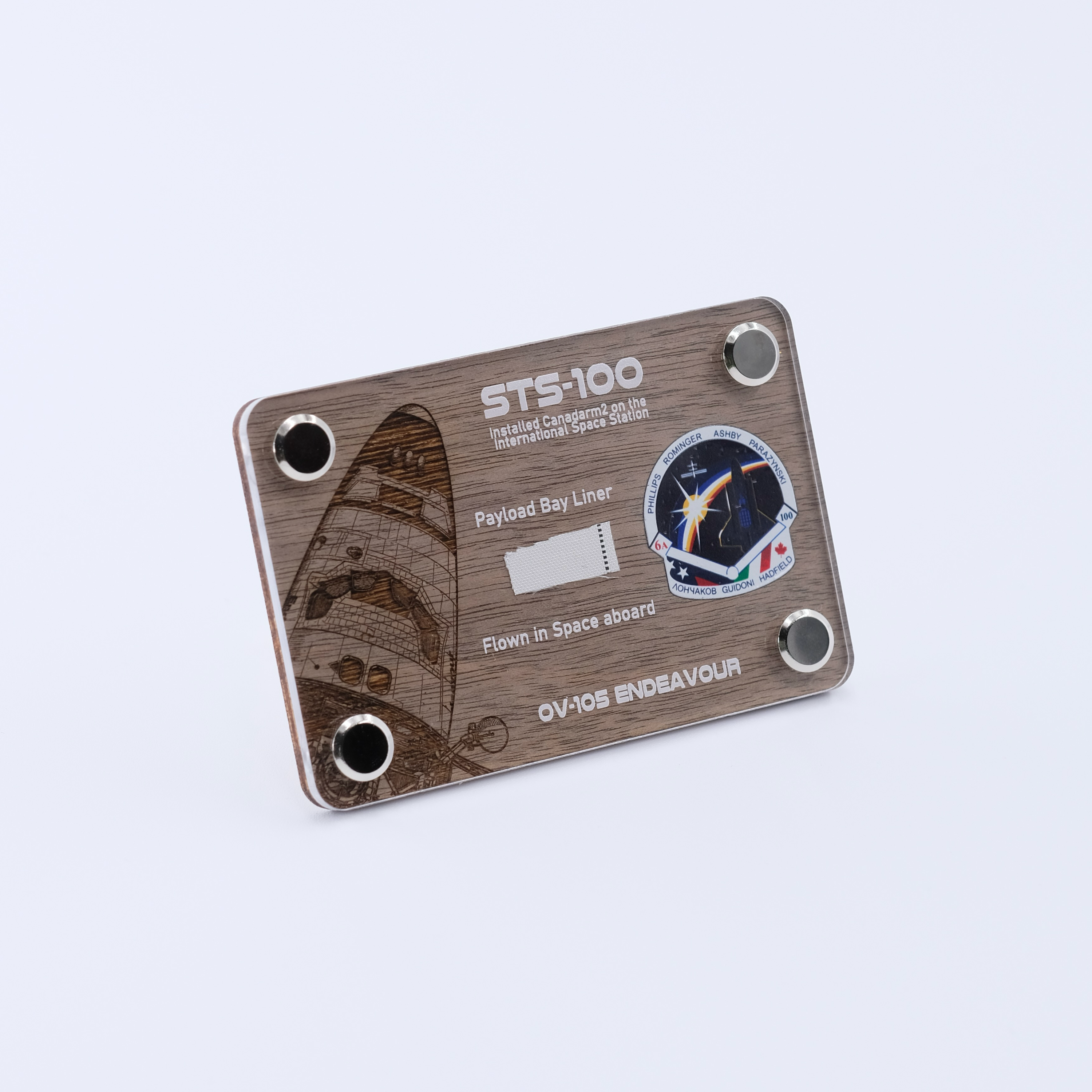 Authentic flown payload bay liner artifact from Space Shuttle Endeavour STS-100, the mission that installed Canadarm2 on the International Space Station, displayed in a handcrafted collectible card.