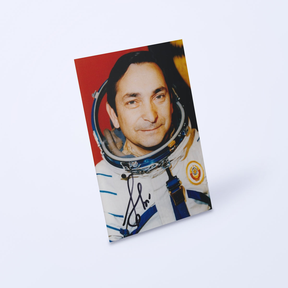 Signed portrait of cosmonaut Valery Bykovsky in a Sokol spacesuit, shown at an angle on a light background