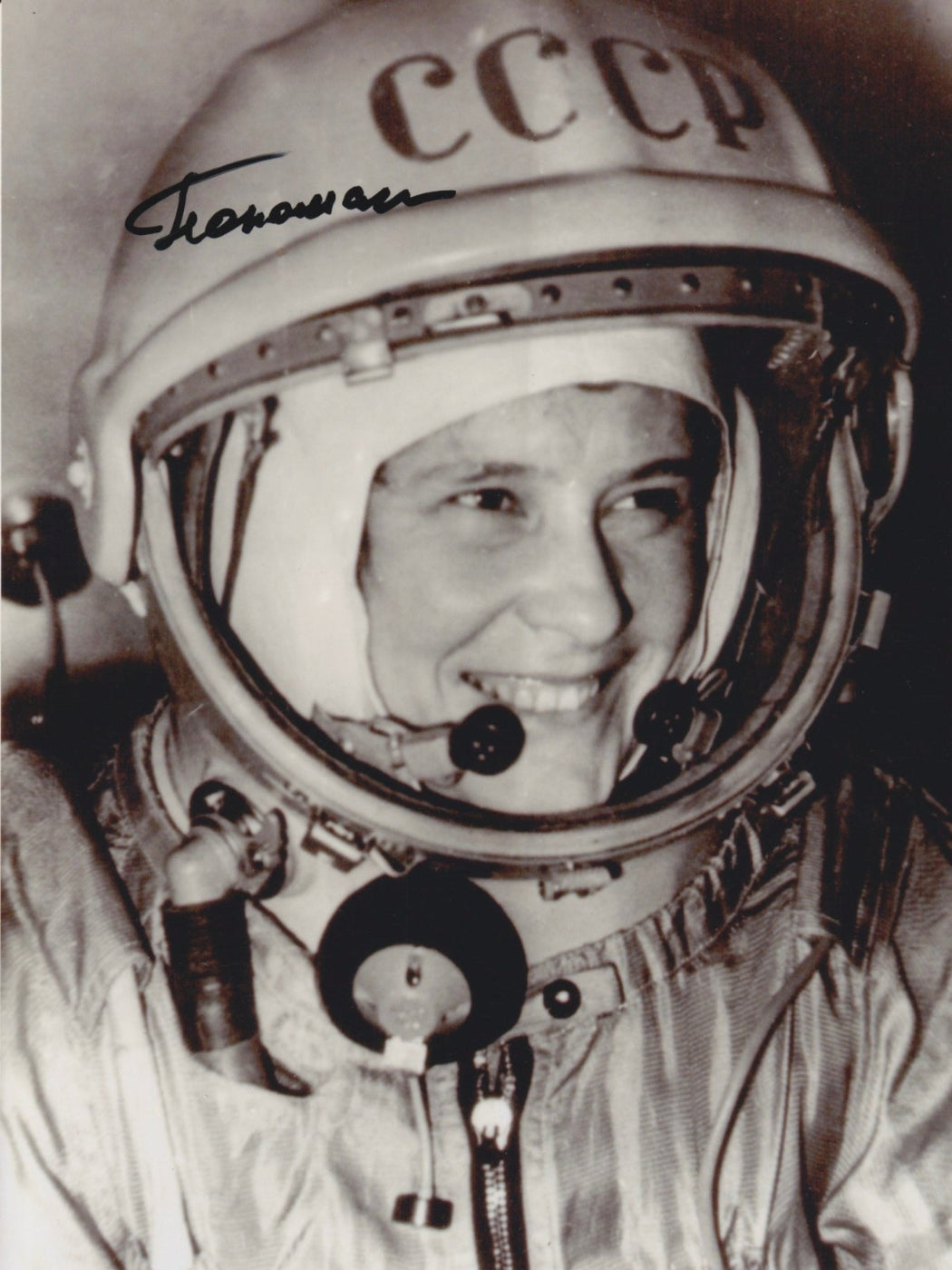 Black-and-white portrait of a smiling Soviet female cosmonaut, Valentina Ponomaryova, in a spacesuit and CCCP helmet, with an autograph on the photo.