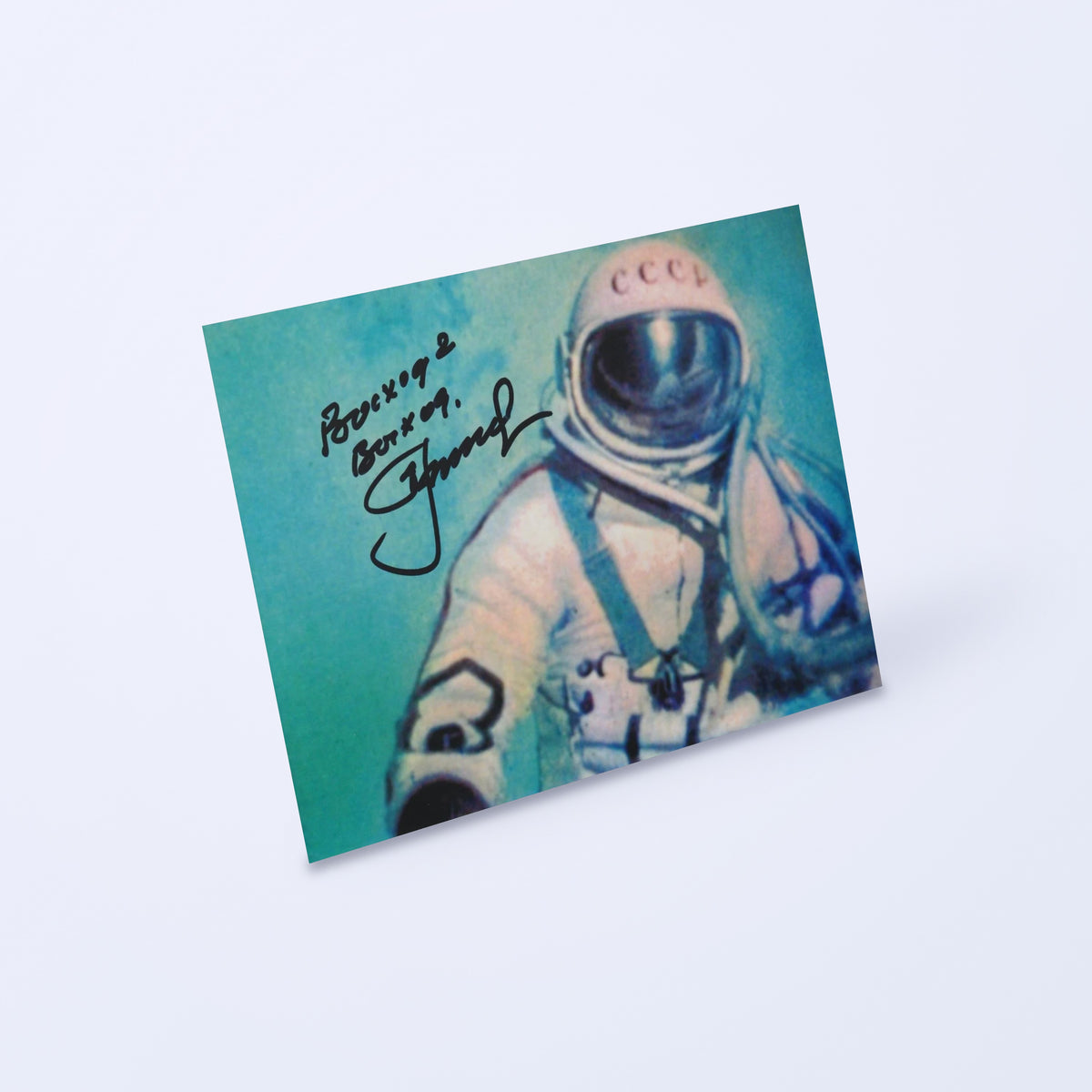 Signed photo of Alexei Leonov during the first spacewalk (Voskhod 2), shown at an angle on a light background