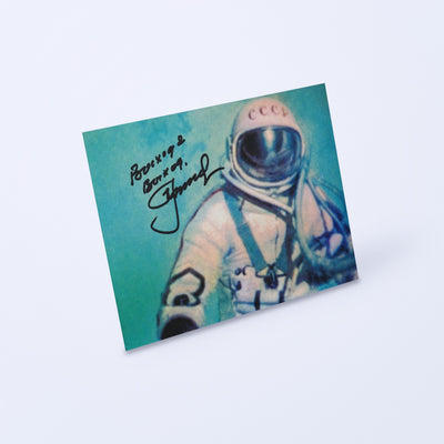 Signed photo of Alexei Leonov during the first spacewalk (Voskhod 2), shown at an angle on a light background