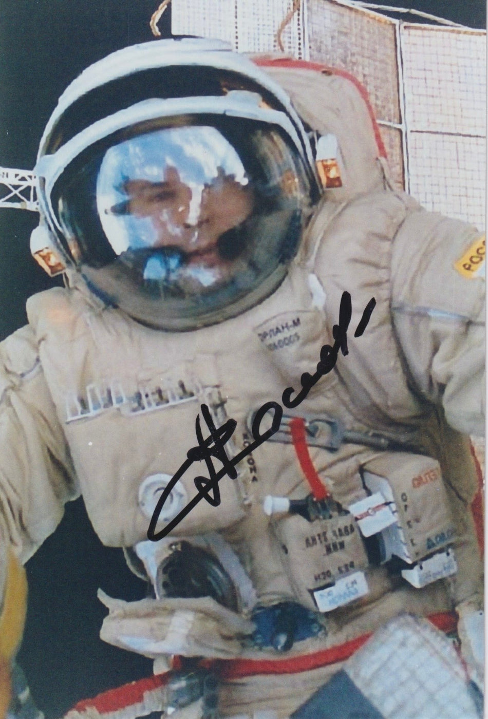 Signed portrait of cosmonaut Anatoly Solovyev in Orlan EVA spacesuit during spacewalk, autograph clearly visible, perfect for space memorabilia collectors