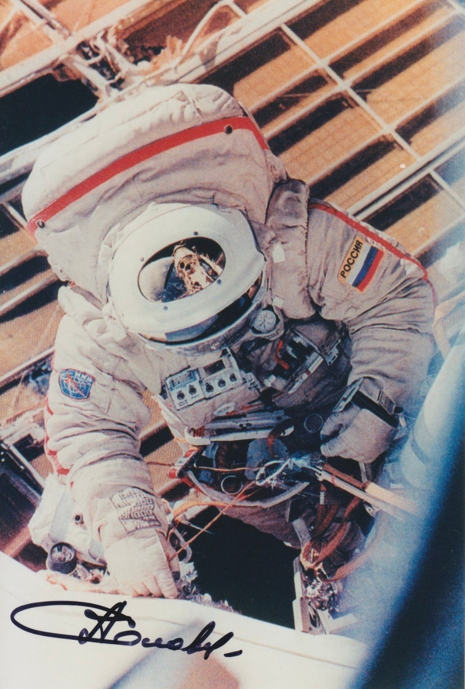 Signed portrait of cosmonaut Anatoly Solovyev in Orlan EVA spacesuit during spacewalk, autograph clearly visible, perfect for space memorabilia collectors
