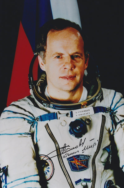 Signed portrait of cosmonaut Anatoly Solovyev in a Sokol spacesuit with mission patch