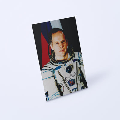 Signed portrait of cosmonaut Anatoly Solovyev in a Sokol spacesuit, shown at an angle on a light background