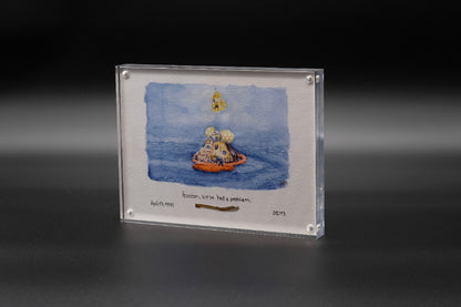 Vertical acrylic display with a watercolor of the Apollo capsule splashdown and an embedded flown spacecraft fragment beneath the artwork.