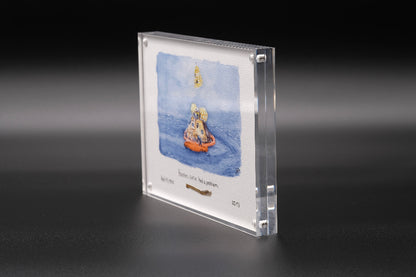 Vertical acrylic display with a watercolor of the Apollo capsule splashdown and an embedded flown spacecraft fragment beneath the artwork.