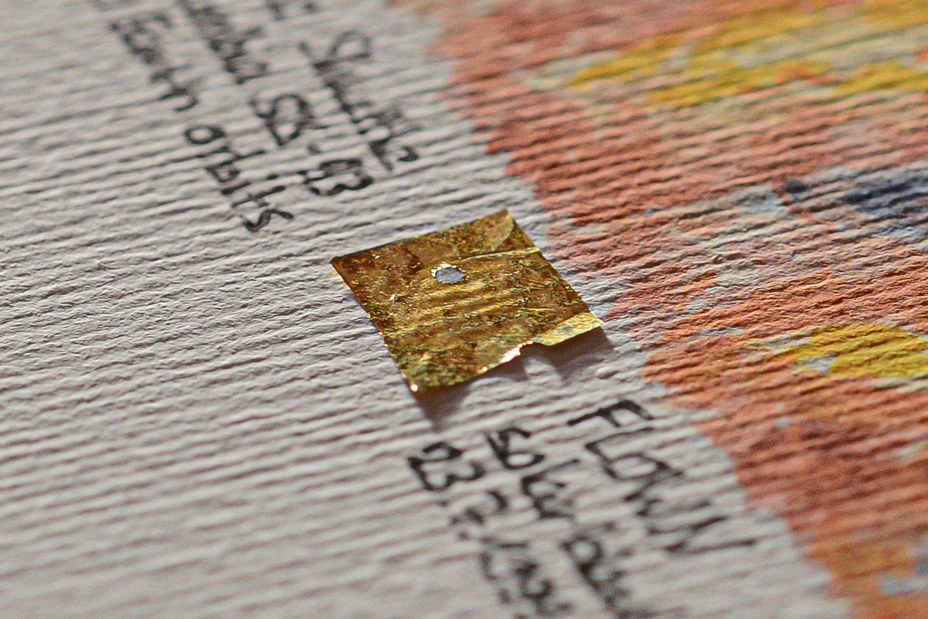Close-up photo of a flown Space Shuttle Columbia STS-93 solar blanket fragment mounted on an artwork card by The New Space Age.