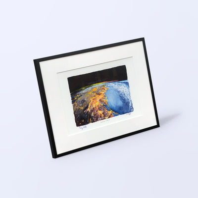 Overview Effect fine art print in a black frame with white mat, shown at an angle on a light background