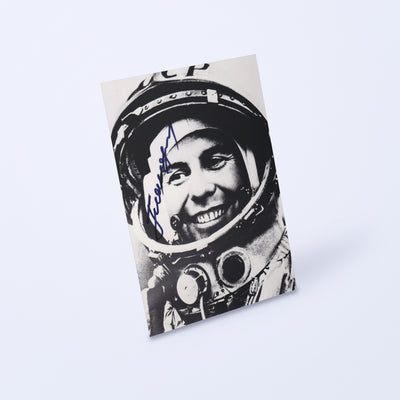 Signed black-and-white portrait of cosmonaut Pavel Popovich with CCCP helmet, shown at an angle on a light background