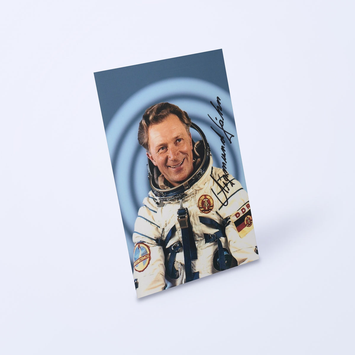Signed portrait of cosmonaut Sigmund Jähn in a Sokol spacesuit, shown at an angle on a light background