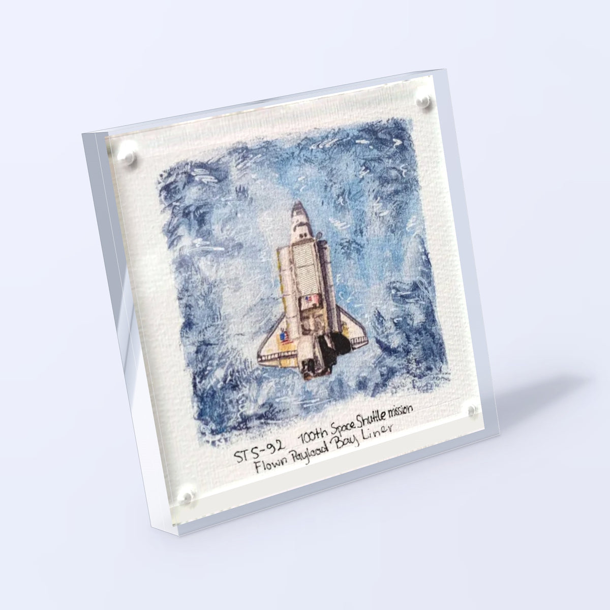 Acrylic display with a Space Shuttle fine art print and a flown STS-92 payload bay liner fragment, angled view