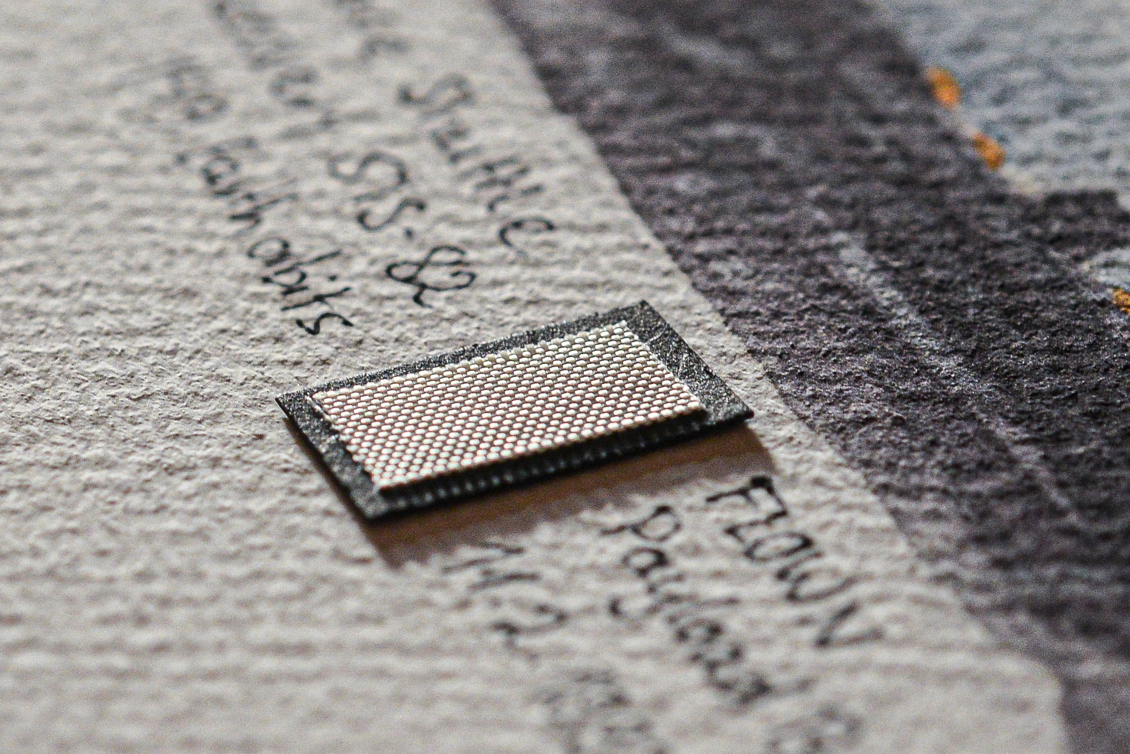 Close-up of a flown Space Shuttle Discovery STS-82 payload bay liner fragment mounted on an artwork card, by The New Space Age.