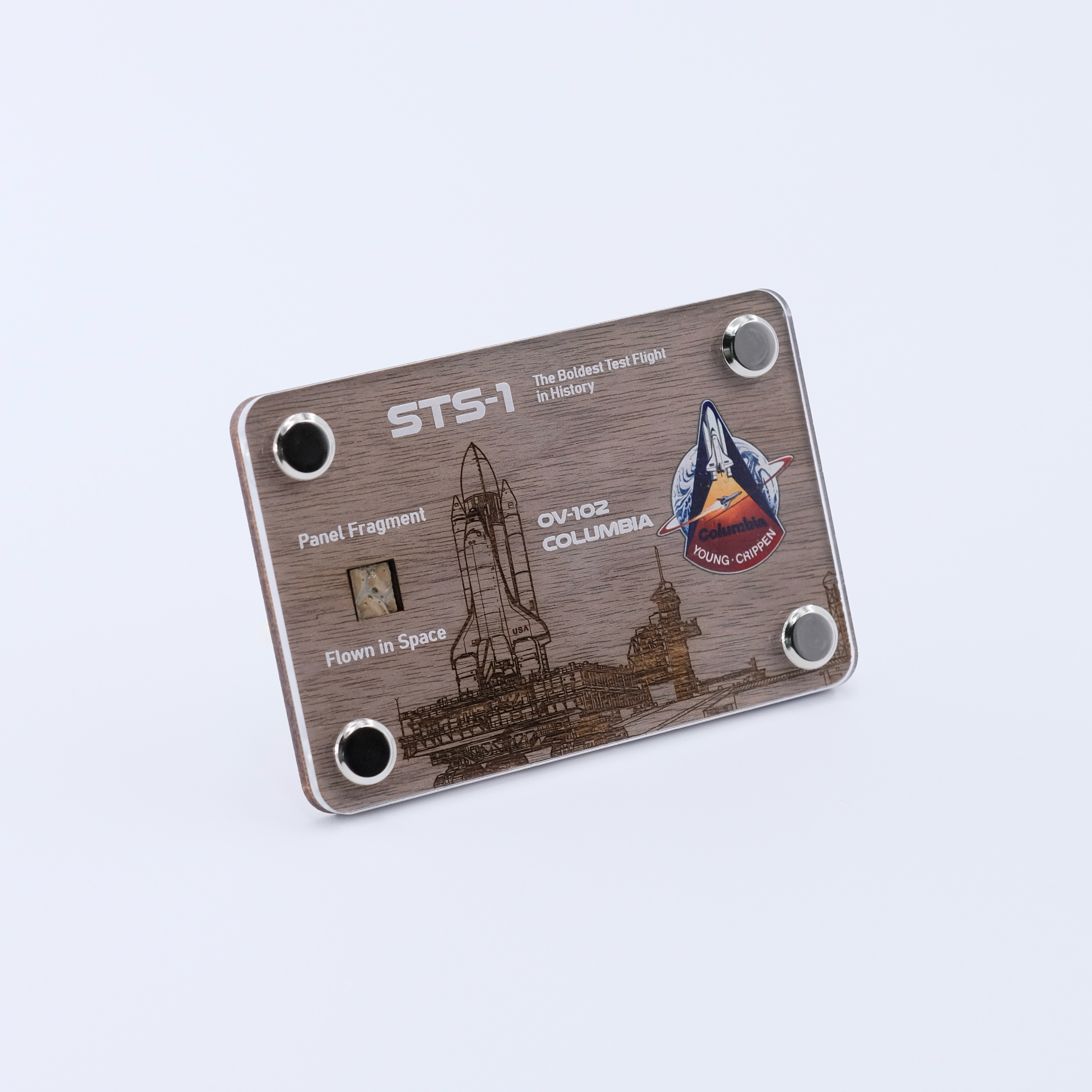 Angled view of an authentic flown panel fragment artifact display card from Space Shuttle Columbia STS-1, the first Space Shuttle mission and maiden flight of the Space Shuttle program.