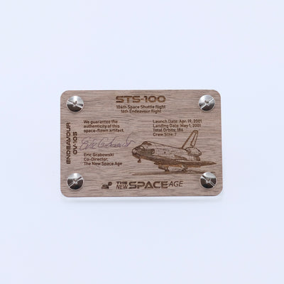 Back side of the STS-100 Endeavour flown payload bay liner artifact display card featuring mission details, authenticity statement, and Space Shuttle Endeavour engraving.