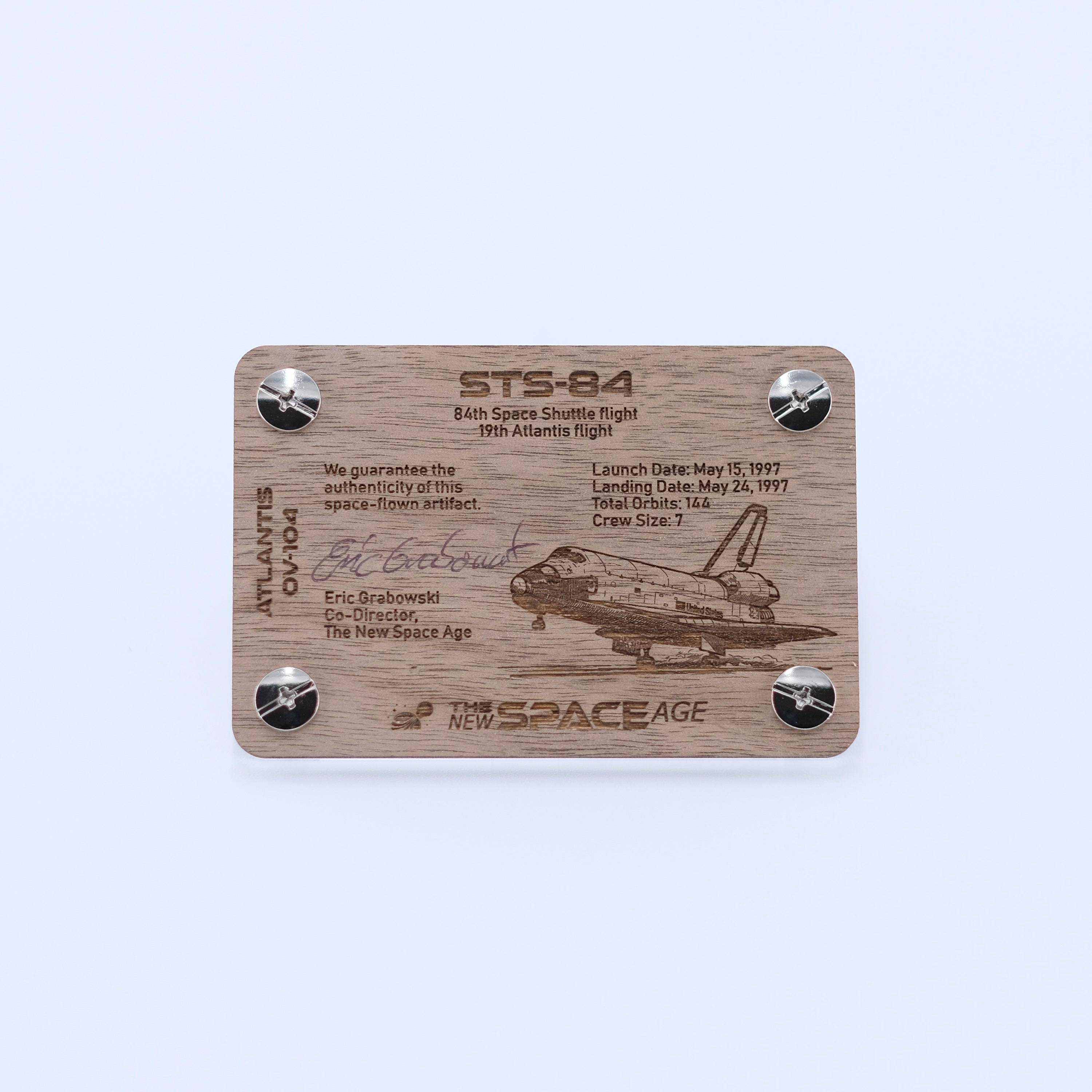 Back side of the STS-84 Atlantis flown gap filler artifact display card featuring mission details, authenticity statement, and Space Shuttle Atlantis engraving.