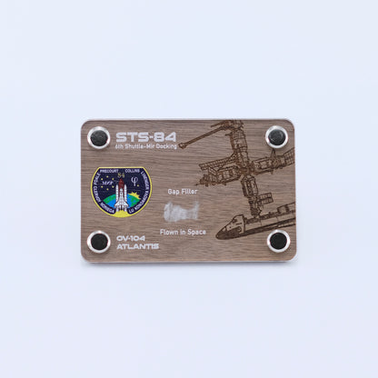 Authentic flown gap filler artifact from Space Shuttle Atlantis STS-84, the sixth Shuttle-Mir docking mission, displayed in a handcrafted collectible card.