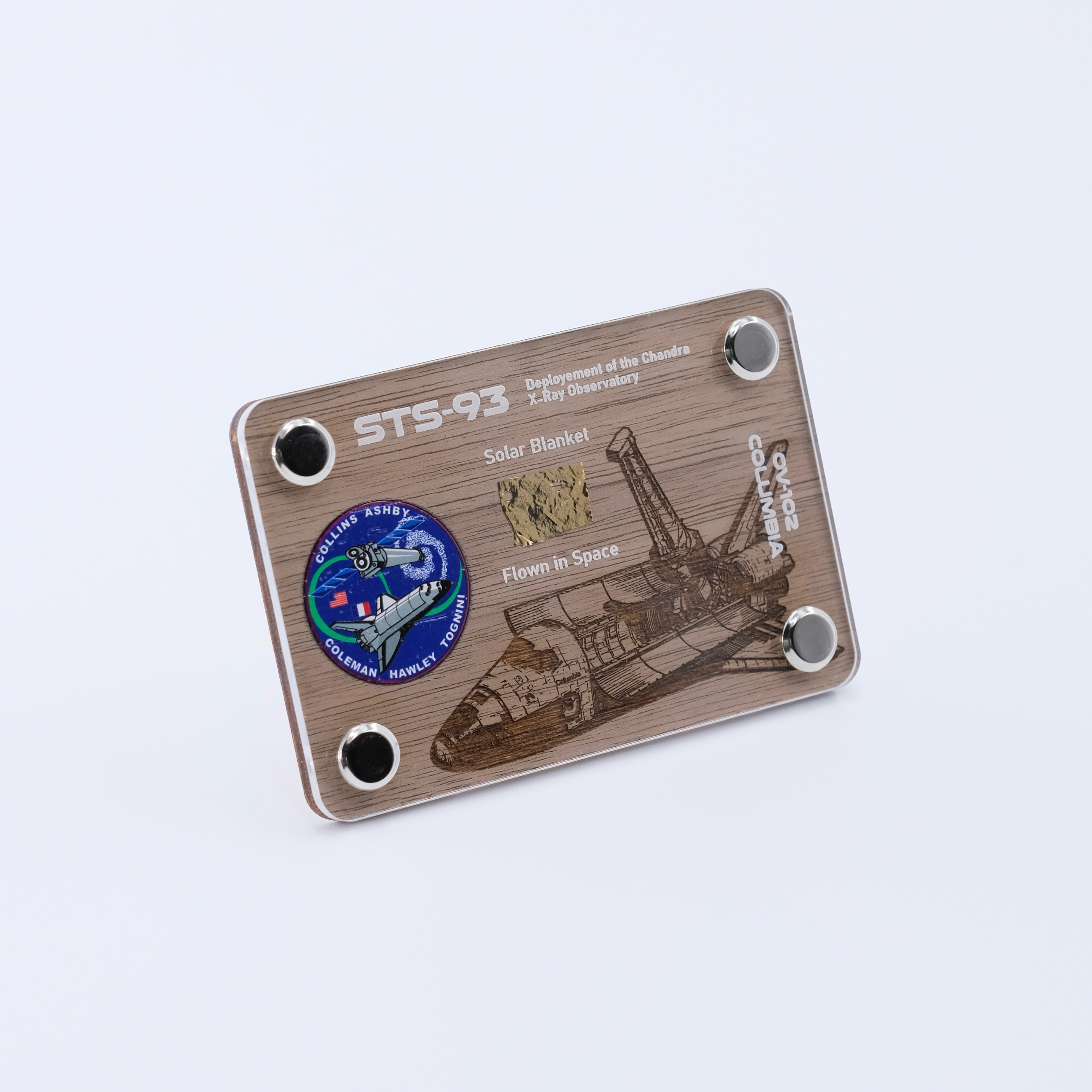 Angled view of an authentic flown solar blanket artifact display card from Space Shuttle Columbia STS-93, the mission that deployed the Chandra X-ray Observatory.