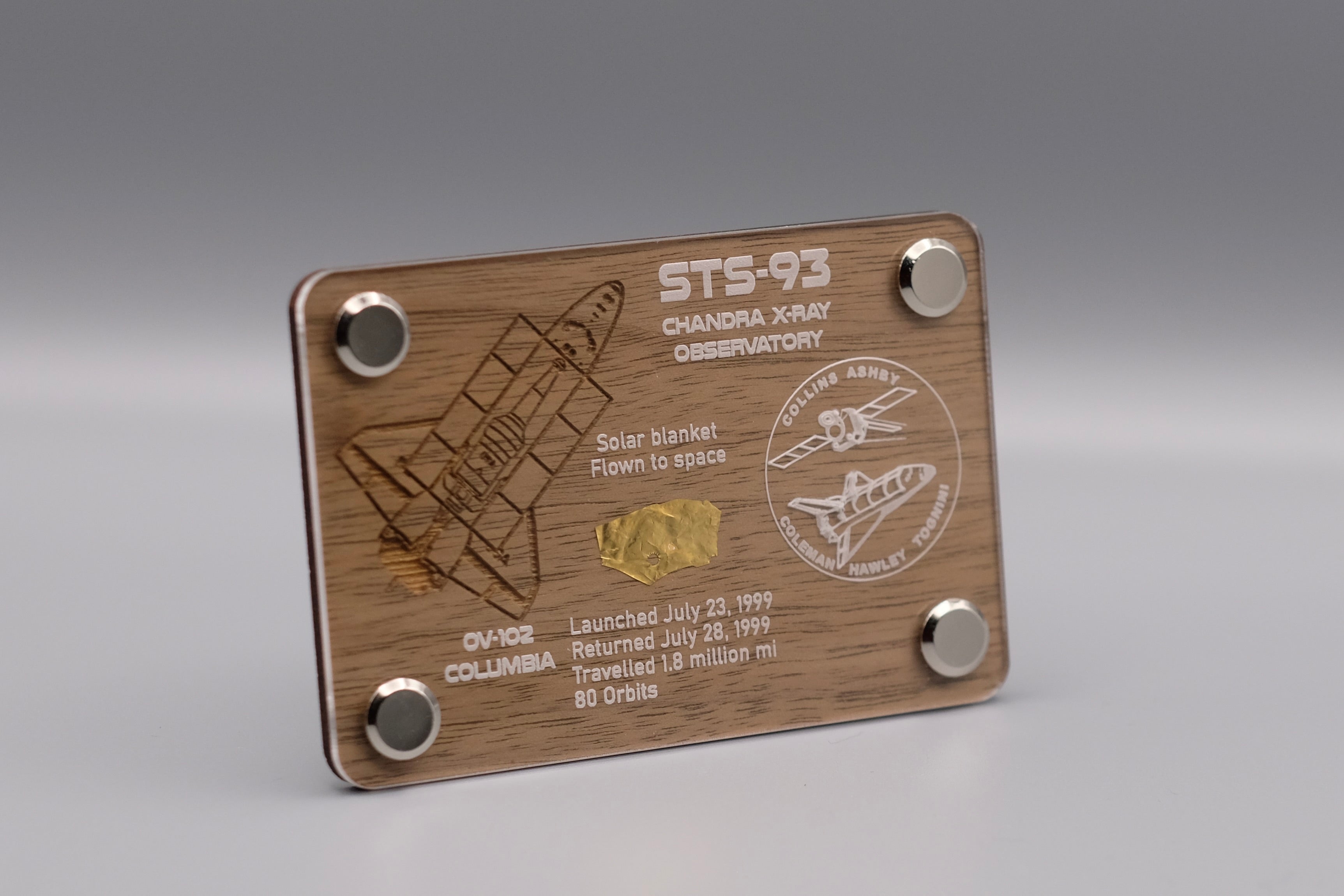 Premium wooden display with flown solar blanket fragment from Space Shuttle Columbia STS-93 mission, featuring engraved mission details and Chandra X-ray Observatory emblem.