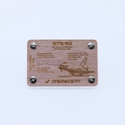 Back side of the STS-94 Columbia flown thermal blanket artifact display card featuring mission details, authenticity statement, and Space Shuttle Columbia engraving.
