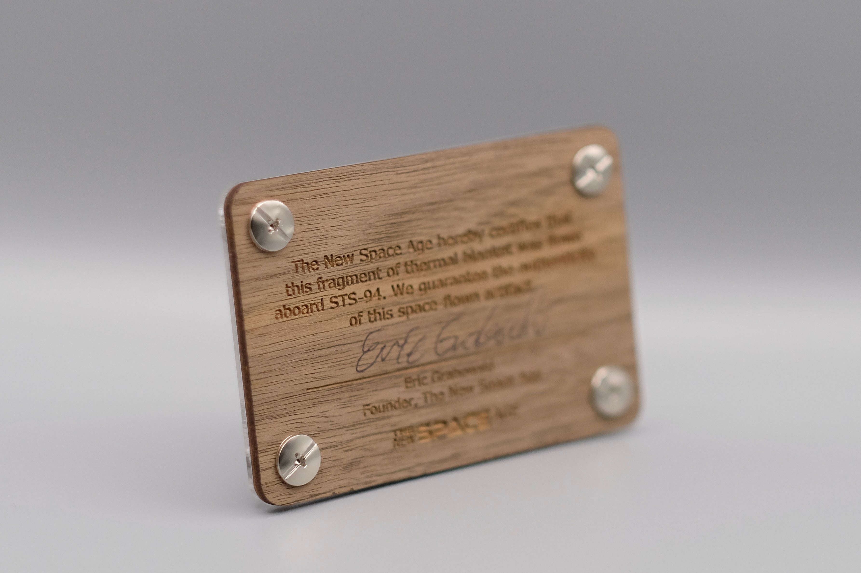 Backside of STS-93 flown solar blanket display, showing engraved authenticity text and founder signature from The New Space Age.