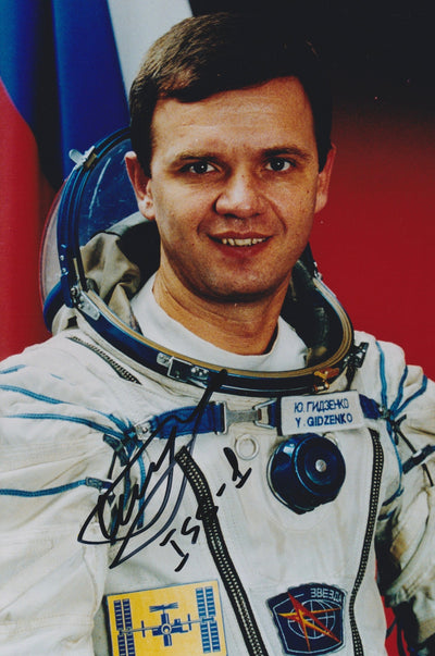 Signed portrait of cosmonaut Yuri Gidzenko in a Sokol spacesuit with mission patches
